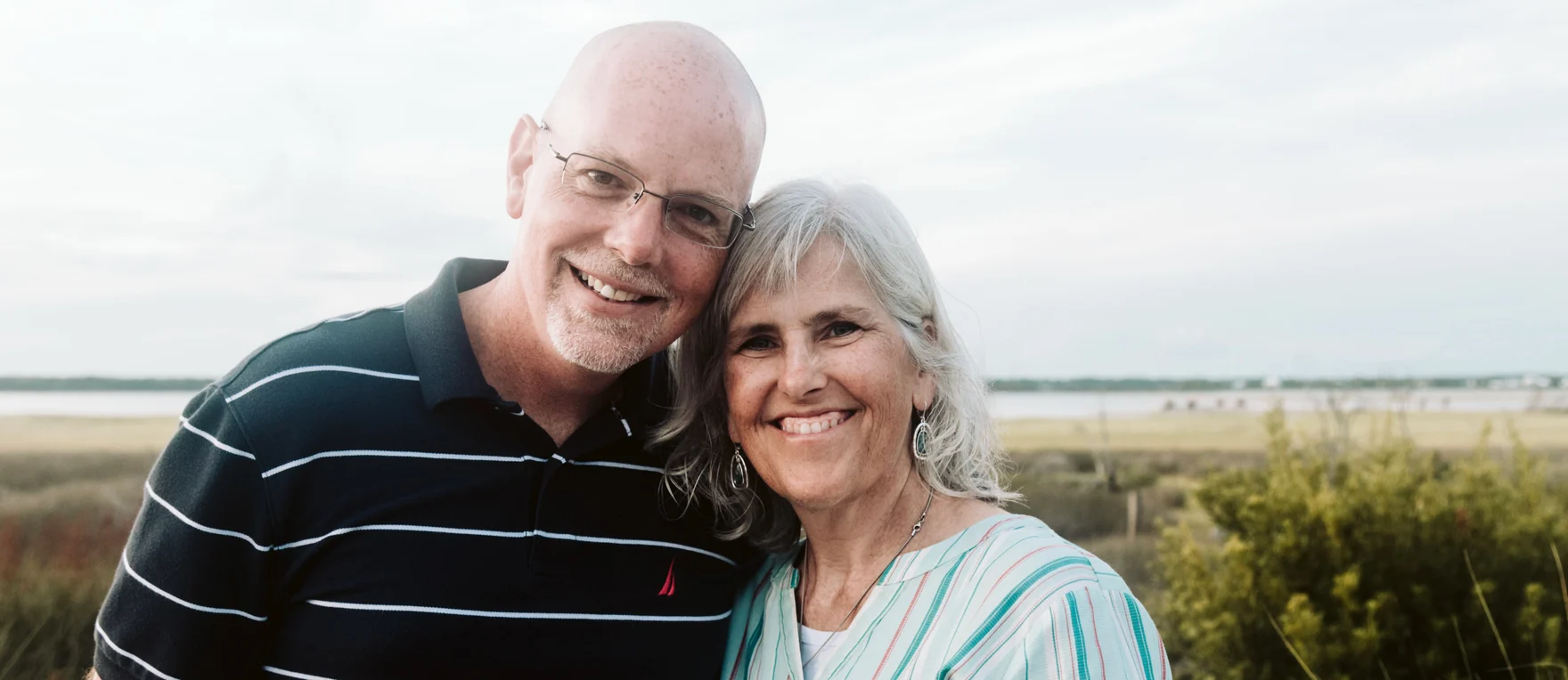 Jason and Janet Dohm standing together near the water